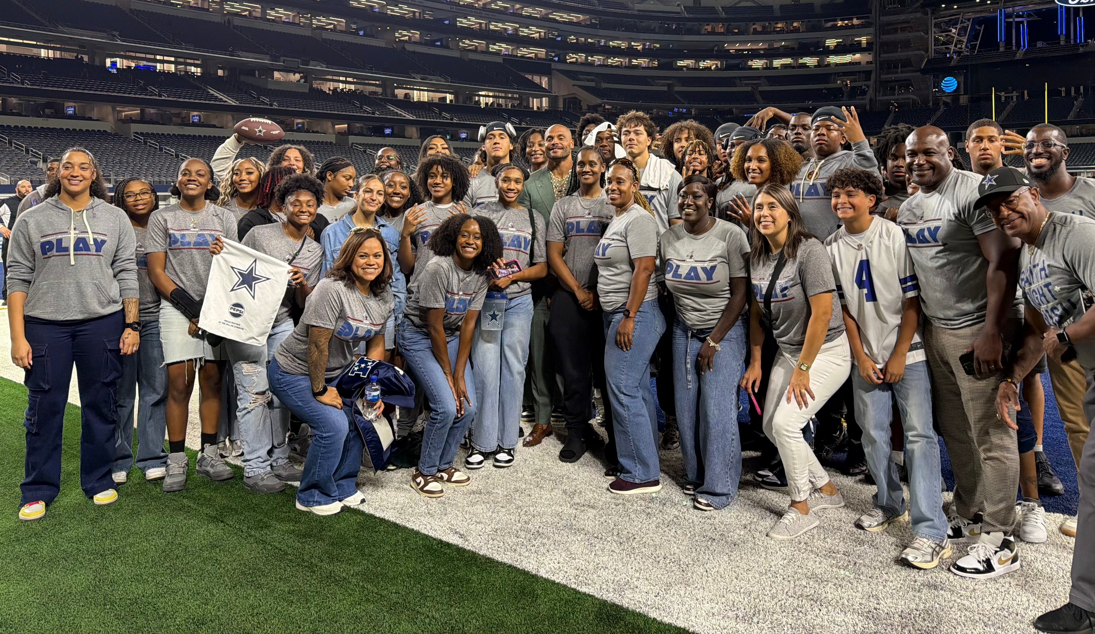 Group of people posing for a photo at a Faith Fight Finish event, with stadium seats and lights in the background.